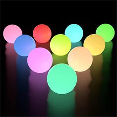 several different colored lights on a black surface