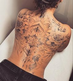 the back of a woman's body with tattoos on it