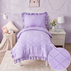 a bed with purple comforter and pillows in a bedroom next to a white rug