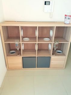 a cabinet with glass doors and shelves in the middle of a floored room that has white tiles on it