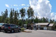 two vehicles are parked in front of a building with a gas station on the corner