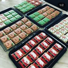 several trays filled with decorated cookies on top of a table