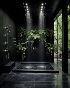 a black bathroom with plants growing on the wall and shower head in the middle,