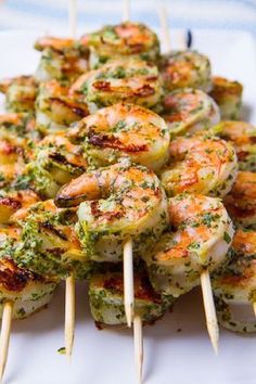 grilled shrimp and broccoli on skewers with text overlay that reads, how to make the most deliciousest camarones at all pesto