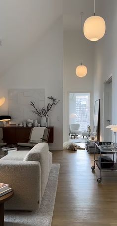 a living room filled with furniture and lots of lights hanging from the ceiling above it