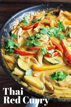 a skillet filled with chicken, peppers and zucchini sauce on top of a wooden table