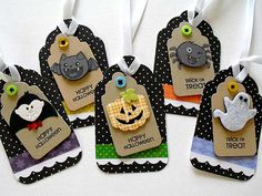 six halloween tags hanging from strings on a table