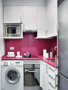 a kitchen with white cabinets and pink counter tops