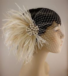 a woman's head wearing a veil with feathers and pearls on the top of it