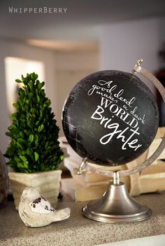 a black and white globe sitting on top of a counter next to potted plants