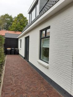 a brick walkway leading to a white house