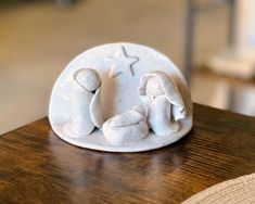 a white ceramic figurine sitting on top of a wooden table