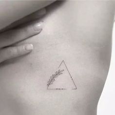 a woman's stomach with a small triangle tattoo on it