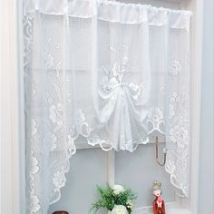 a window with white lace curtains and vases on the shelf next to each other