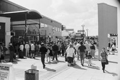 a crowd of people walking down a street next to tall buildings