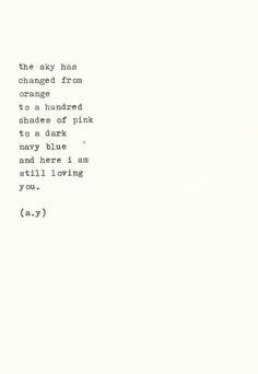 an old typewriter with the words'the sky has changed from orange to shades of pink to a dark blue and here i am still loving you