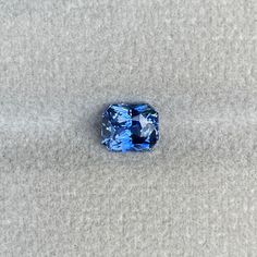 a blue diamond sitting on top of a gray carpet