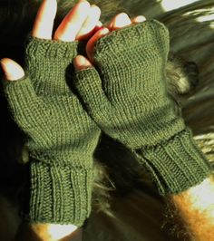 "Fingerless men's gloves are hand knit in moss green 100% superwash merino wool.   They are knit with ribbing at the wrist and knuckles for fit, and smooth stockinette stitch throughout the rest of the hand.   This style of glove includes a half thumb and one opening for all four fingers; they leave fingertips free while providing warmth to the hand.   The fabric is soft, durable and warm.  This heathered mossy green is one of my favorites.  At first glance it looks solid. but close up you can see many shades contribute to the rich color.  I tried to show this in the last photograph. One size fits most.  Laid flat, the wrist opening is approximately 6 inches in circumference, but the ribbed material allows for plenty of stretch. The gloves are approximately 9 inches end to end, and the thu Knit Handwarmers, Fingerless Gloves Men, Four Fingers, Wool Fingerless Gloves, Gloves Men, Texting Gloves, Wool Gloves, Green Outfit, Stockinette Stitch