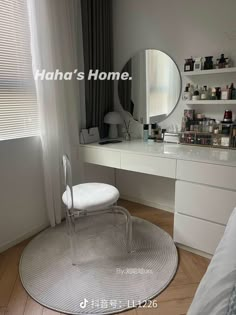 a white chair sitting in front of a mirror on top of a dresser next to a window