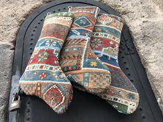 three pieces of multicolored rug sitting on top of a piece of black metal