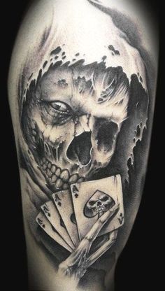 a man with a skull and playing cards tattoo on his arm is shown in black and white