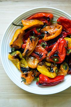 a white bowl filled with red and yellow peppers