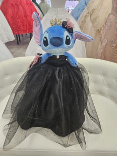 a stuffed animal in a black dress on display at a wedding shop with other dresses and gowns behind it