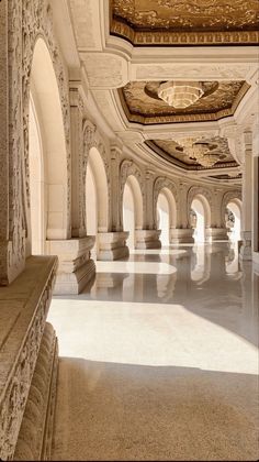 the inside of a large building with arches and columns on either side of the room