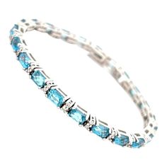 indulge in the allure of our Blue Topaz Bracelet, a testament to refined glamour and timeless style. Meticulously crafted in 14K Yellow Gold, this exquisite piece boasts a mesmerizing 20 cttw Blue Topaz, capturing the essence of the clear blue skies. Complemented by 1.00cttw Round Brilliant Cut Diamonds, the bracelet exudes a subtle brilliance. With average length of 7 inches, it drapes your wrist in sophistication. Unveil a world of elegance – explore our Blue Topaz Bracelet now and let the enc Bracelet With Diamonds, Topaz Bracelet, Bracelet Tennis, Blue Topaz Bracelet, Modern Bracelets, Police Dept, Clear Blue Sky, Swiss Blue Topaz, Blue Skies