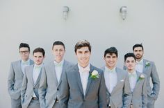 a group of men standing next to each other wearing suits and bow ties on their heads