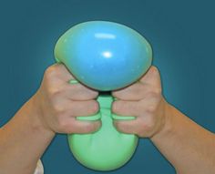 a person holding a blue and green ball in front of their face with both hands