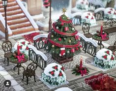 a christmas tree surrounded by small tables and chairs with decorations on them in the snow