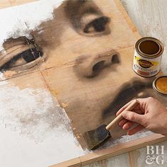 a person is painting on a piece of wood