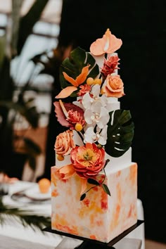 a wedding cake decorated with flowers and greenery