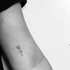 a single flower tattoo on the left arm