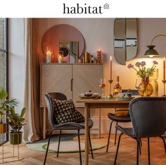 a dining room with chairs and a table in front of a large window that has candles on it