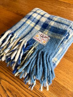 a blue and white plaid blanket sitting on top of a wooden floor