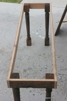 a wooden table sitting on top of a cement ground