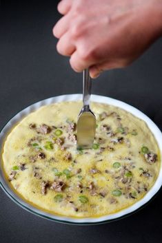 a person using a spatula to dip food in a bowl