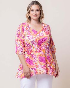 Opt for relaxed luxe style with the Oasis Flowy Swing Tunic Top. This flattering shirt has a modest v-neck, well-placed gathering and elbow length sleeves. Made from a lightweight rayon, this plus size summer top is ideal for curvy ladies escaping to a tropical beach resort or relaxing on a cruise. This versatile dressy blouse can be styled as business casual or as a chic party outfit for an evening cocktail. Available in beautiful prints of white, pink, orange and blue in women's clothing sizes Relaxed Fit V-neck Blouse For Brunch, Chic Party Outfit, Jumpsuit And Cardigan, Plus Size Summer Tops, Chic Cardigan, Plus Size Summer Outfit, Luxe Style, The Oasis, Beautiful Prints