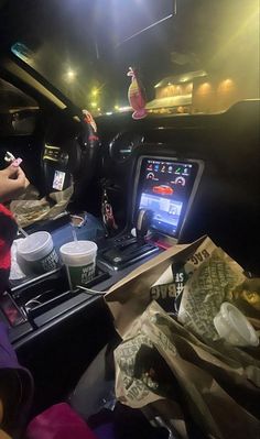 the interior of a car with food and drinks on the table in front of it