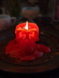 a red candle that is sitting on a plate