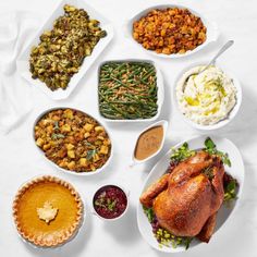 a table topped with plates filled with different types of thanksgiving foods and condiments