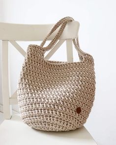 a crocheted bag sitting on top of a white chair