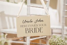 a sign that says uncle john here comes your bride hanging from the back of a chair