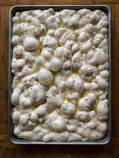 a metal pan filled with cauliflower on top of a wooden table