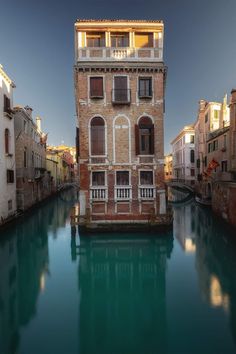 an old building sitting on the side of a river