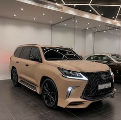 two suvs are parked in a showroom