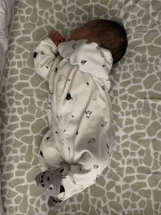 a baby is sleeping on a giraffe print blanket