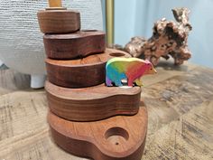 a bear figurine sitting on top of a wooden block in front of a wood sculpture